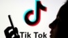 FILE - A person holds a smartphone as Tik Tok logo is displayed behind in this picture illustration taken Nov. 7, 2019. 