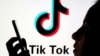 FILE - A person holds a smartphone as Tik Tok logo is displayed behind in this picture illustration taken Nov. 7, 2019. 