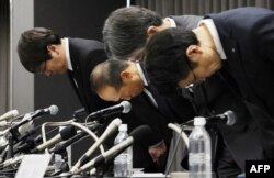 President of Kobayashi Pharmaceutical Co.  Akihiro Kobayashi (second from left) along with several top company officials, bows at the start of a press conference in Osaka, March 29, 2024. (JIJI Press / AFP)