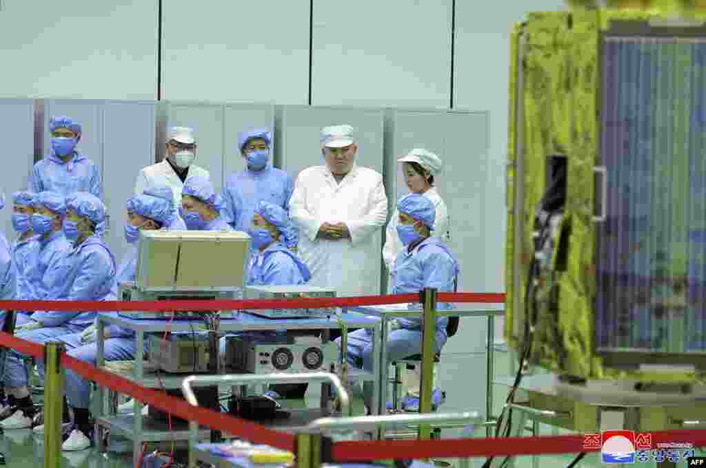 North Korean leader Kim Jong Un, 2nd right at top, and his daughter, presumed to be named Ju Ae, right at top, inspect a military reconnaissance satellite at an undisclosed location in North Korea, in this picture taken on May 16, 2023, and released May 17. Kim Jong Un has inspected North Korea&#39;s first military spy satellite and gave the go-ahead for its &quot;future action plan,&quot; state media said on May 17. (Photo by KCNA via KNS / AFP)