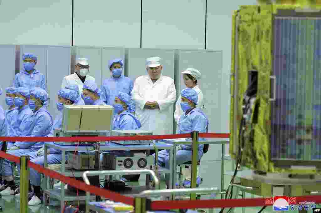 North Korean leader Kim Jong Un, 2nd right at top, and his daughter, presumed to be named Ju Ae, right at top, inspect a military reconnaissance satellite at an undisclosed location in North Korea, in this picture taken on May 16, 2023, and released May 17. Kim Jong Un has inspected North Korea&#39;s first military spy satellite and gave the go-ahead for its &quot;future action plan,&quot; state media said on May 17. (Photo by KCNA via KNS / AFP) Севернокорејскиот лидер Ким Јонг Ун, и неговата ќерка, за која се претпоставува дека се вика Џу Ае го прегледуваат воениот сателит за извидување на неоткриена локација во Северна Кореја. Фотографијата е направена на 16 мај 2023 година. Ким Јонг Ун го прегледа првиот воен шпионски сателит на Северна Кореја и даде зелено светло за нејзиниот &bdquo;иден акционен план&ldquo;, објавија државните медиуми на 17 мај. (Фортографија на KCNA преку KNS/AFP)