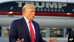 FILE - Former President Donald Trump speaks with reporters before departure from Hartsfield-Jackson Atlanta International Airport, in Atlanta, Aug. 24, 2023.