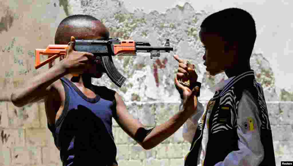 Somali boys play with a replica of a gun, in Waberi district of Mogadishu, Somalia.