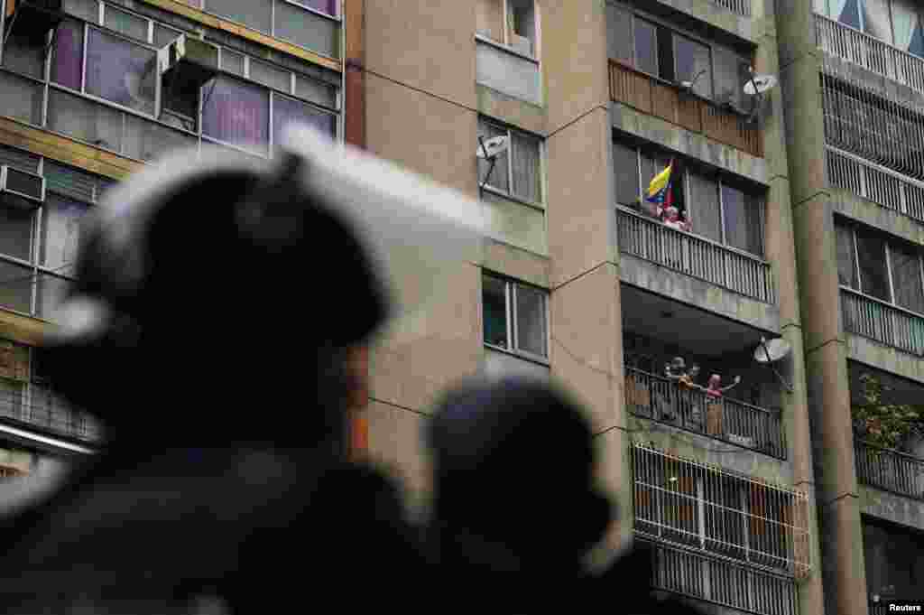 Partidarios del presidente de Venezuela, Nicolás Maduro, hacen gestos desde sus apartamentos durante una marcha en Caracas, el 29 de julio de 2024.