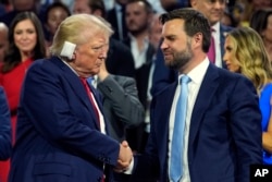 El candidato presidencial republicano, el ex presidente Donald Trump, y el candidato republicano a la vicepresidencia, el senador por Ohio JD Vance, asisten al primer día de la Convención Nacional Republicana, el lunes 15 de julio de 2024, en Milwaukee. (Foto AP/Evan Vucci)