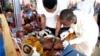 FILE - Health officials attend to children suffering malnutrition in a clinic set up by health authorities in collaboration with Doctors Without Borders at Mashi, in northwest Nigeria, on July 22, 2022.