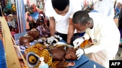 FILE - Health officials attend to children suffering malnutrition in a clinic set up by health authorities in collaboration with Doctors Without Borders at Mashi, in northwest Nigeria, on July 22, 2022.