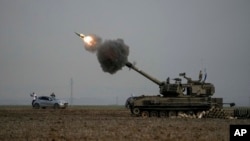 An Israeli mobile artillery unit fires a shell from southern Israel towards the Gaza Strip, in a position near the Israel-Gaza border Dec. 14, 2023.