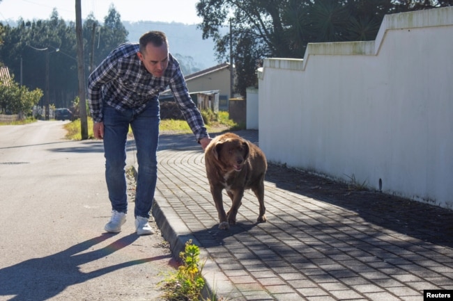 Leonel Costa pasea al perro, Bobi, que rompió el récord del perro más adulto de la historia, en Conqueiros, en Leiria, Portugal, el 4 de febrero de 2023. REUTERS/Catarina Demony