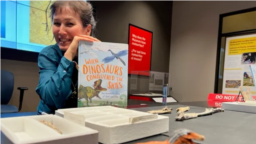 Writer and paleontologist Jingmai O’Connor holds WHEN DINOSAURS CONQUERED THE SKIES , published by The Quarto Group (Photo: Lisa Fielding)