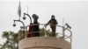 Combatientes talibanes observan desde una torre en la Embajada de EEUU durante una manifestación en Kabul, Afganistán, el 12 de abril de 2022.