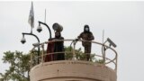 FILE - Taliban fighters keep watch from a tower at the US embassy as people (unseen) demonstrate against videos of allegedly showing Afghan refugees being beaten by Iranians went viral, near the Ahmad Shah Massoud square in Kabul, Apr. 12, 2022.