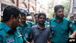 Police escort reporter Shamsuzzaman Shams (C), who has been arrested and charged under the Digital Security Act, to a court in Dhaka, Bangladesh, March 30, 2023.