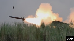FILE - An M142 High Mobility Artillery Rocket System (HIMARS) fires during Phillipine-U.S. exercises at Capas, Philippines, Oct. 13, 2022. The White House on Feb. 24, 2023, said it would send more military aid to Ukraine, including HIMARS ammunition.