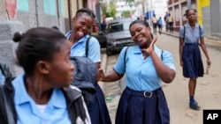 Students strike poses at the end of their school day, in Cap-Haitien, Haiti, April 17, 2024.