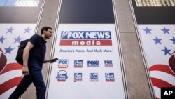 FILE - A person walks past the Fox News Headquarters in New York, April. 12, 2023.
