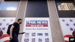 FILE - A person walks past the Fox News Headquarters in New York, April. 12, 2023.