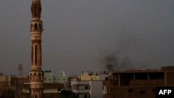 Smoke billows behind buildings in southern Khartoum, Sudan, May 27, 2023, amid ongoing fighting between the forces of two rival generals.