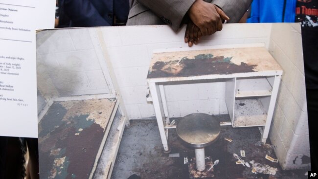 ARCHIVO - El abogado Michael Harper sostiene una foto de la celda de Lashawn Thompson en la cárcel del condado de Fulton, Georgia, en una conferencia de prensa sobre los resultados de una autopsia independiente que determinó la causa de la muerte de Thompson, el 22 de mayo de 2023, en la capital del estado en Atlanta.