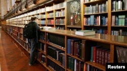 FILE - A woman stands among the bookshelves in the main reading room of The New York Public Library, December 14, 2004. (REUTERS/Mike Segar)