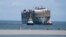 Cargo ship Fremantle Highway, which caught fire while transporting thousands of cars from Germany to Singapore, is towed into the port of Eemshaven, Netherlands, Aug. 3, 2023. 