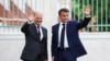Kanselir Jerman Olaf Scholz dan Presiden Prancis Emmanuel Macron mekambaikan tangan saat bertemu di Istana Meseberg, di utara Berlin, Jerman, pada 28 Mei 2024. (Foto: Reuters/Liesa Johanssen)