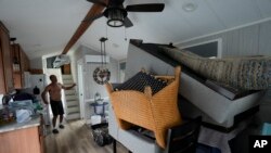 Furniture is piled high inside the canal-front home of Victor Cassano in Suwannee, Florida, as Cassano prepares for the arrival of Hurricane Idalia, Aug. 29, 2023.