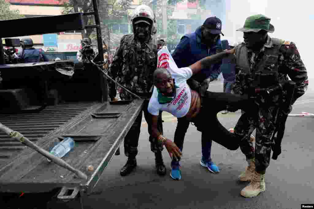 Police detains Kenyan activist Boniface Mwangi during an anti-government demonstration following nationwide deadly riots over tax hikes and a controversial now-withdrawn finance bill, in Nairobi.