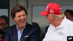 Журналист Такер Карлсон (слева) и бывший президент США Дональд Трамп (справа) во время турнира по гольфу в Бедминстере, штат Нью-Джерси, 31 июля 2022 года.
