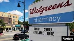 FILE - A sign advertises COVID-19 vaccine shots at a Walgreens Pharmacy in Somerville, Massachusetts, Aug. 14, 2023. 