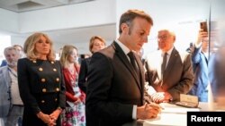 Presiden Prancis Emmanuel Macron dan istrinya Brigitte Macron berkunjung ke Museum Holocaust Memorial di Berlin, Jerman, pada 27 Mei 2024. (Foto: Markus Schreiber/Pool via Reuters)