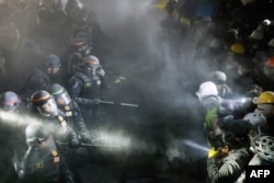 FILE - Cops face-off with pro-Palestinian students after destroying part of the encampment barricade on the campus of the University of California, Los Angeles (UCLA) in Los Angeles, May 2, 2024.