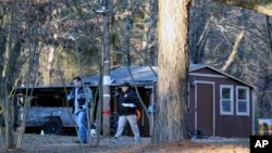 Law enforcement personnel investigate one of the scenes of multiple shootings on Arkabutla Dam Road in Arkabutla, Mississippi, on Feb. 17, 2023. 