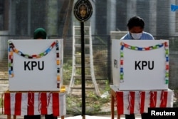 Pemilih sedang memberikan suara politik mereka di TPS saat pemilihan kepala daerah di Tangerang, Banten, 9 Desember 2020. (Foto: REUTERS/Willy Kurniawan)