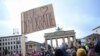 Seorang individu memegang plakat yang bertuliskan 'For democracy' saat demonstrasi ekstremisme kanan dari Partai Alternatif untuk Jerman (AfD) di Berlin, Jerman, 14 Januari 2024. (Foto: REUTERS/Annegret Hilse)