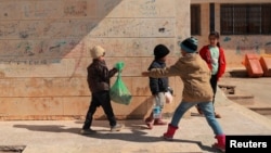 A child carries a bag of bread at a school that shelters families impacted by a deadly earthquake, in Jableh, Syria, Feb. 16, 2023.