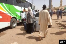 People gather at a bus station in southern Khartoum to leave the Sudanese capital to safer areas, on May 19, 2023, as battles continue between the army and paramilitary forces led by rival generals.