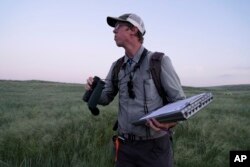 Daniel Horton, field biologist with the Bird Conservancy of the Rockies, conducts a grassland bird survey on June 20, 2023, in Potter, Nebraska.