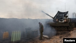 Izraelski vojnik stoji pored mobilne artiljerijske jedinice, u blizini granice između Izraela i Libana, na sjeveru Izraela, 15. januara 2024.