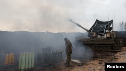 An Israeli soldier stands by a mobile artillery unit, near the Israel-Lebanon border, in northern Israel, Jan. 15, 2024.