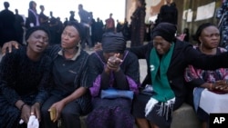 Women react under the bridge during a march in solidarity with the victims of the Christmas Eve attack, in Jos, Nigeria, Jan. 6, 2024.