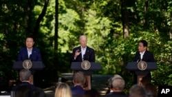 South Korea's President Yoon Suk Yeol, left, and Japan's Prime Minister Fumio Kishida, right, listen as President Joe Biden speaks during a news conference, Aug. 18, 2023, at Camp David, the presidential retreat, near Thurmont, Md.