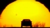 FILE - A motorist is silhouetted against the setting sun on the eve of the vernal equinox, in Shawnee, Kansas, March 19, 2023. Spring gets its official start March 19, 2024, in the Northern Hemisphere. 