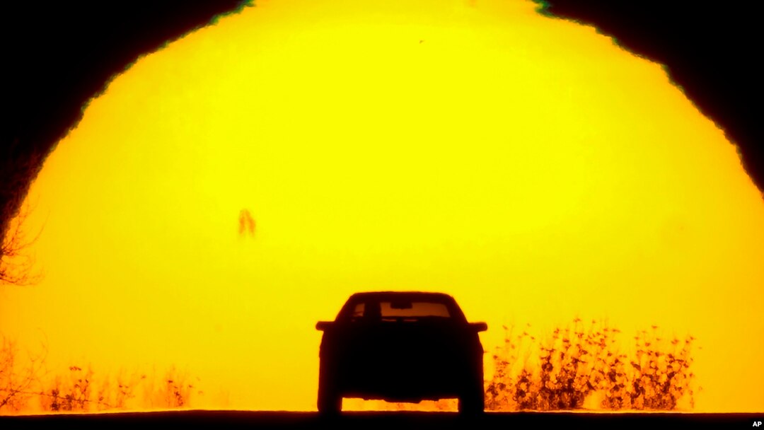 FILE - A motorist is silhouetted against the setting sun on the eve of the vernal equinox, in Shawnee, Kansas, March 19, 2023. Spring gets its official start March 19, 2024, in the Northern Hemisphere. 