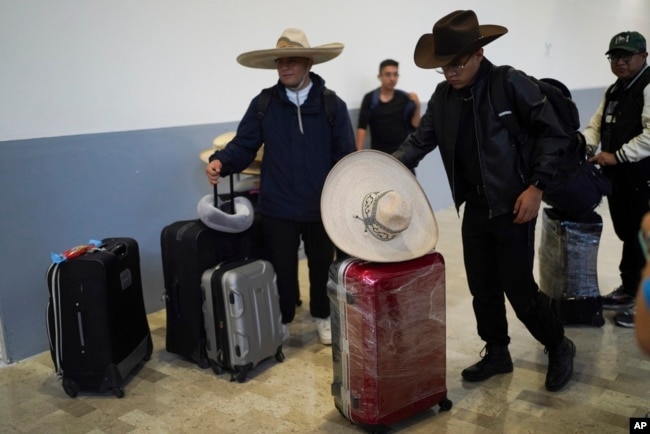 Musisi dari sebuah grup musik negara bagian Hidalgo, Meksiko, menunggu penerbangan baru ke Kolombia setelah penerbangan mereka dibatalkan di bandara internasional Benito Juarez di Mexico City, 19 Juli 2024. Penerbangan mereka terdampak oleh gangguan teknologi massal di dunia.