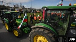FILE - Farmers drive tractors during an action to block trucks crossing the Danube bridge, marking the border between Bulgaria and Romania, in a protest against the duty-free import of grain coming from Ukraine into the EU, in Rousse, Bulgaria, on March 29, 2023.