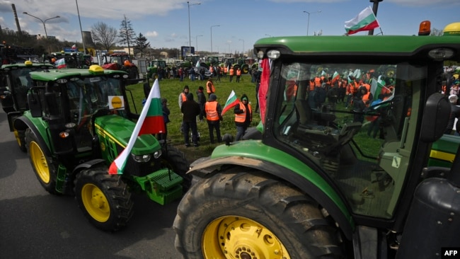 FILE - Farmers drive tractors during an action to block trucks crossing the Danube bridge, marking the border between Bulgaria and Romania, in a protest against the duty-free import of grain coming from Ukraine into the EU, in Rousse on March 29, 2023.