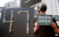 香港47名因受國家安全法指控的民主活動人士的支持者在台北手舉「默站聲援，初選無罪」的標語舉行示威活動。 （ 2021年3月4日）