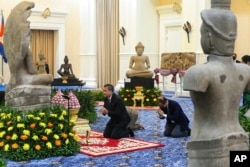 In this photo released by Agence Kampuchea Press (AKP), Cambodian Prime Minister Hun Manet prays before a Buddha statue during a ceremony for the return of artifacts at Peace Palace in Phnom Penh, Cambodia, Thursday, Aug. 22, 2024. (AKP via AP)