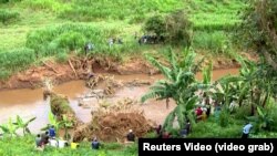 In this image grabbed from Reuters video, people are seen looking on as man floats in river on Del Monte pineapple farm, around 40 kilometers from Nairobi, Kenya on Wednesday December 27, 2023. 